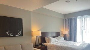 Et hotelværelse med en seng, en sofa, en lampe og et billede på væggen.