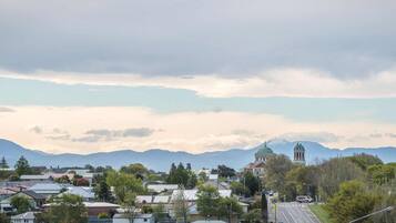 A town with residential houses, a church with a dome, and mountains in the background.