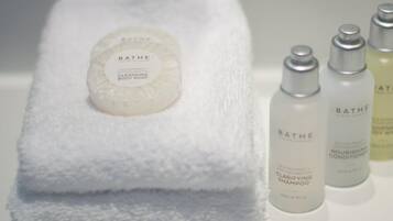 Una toalla blanca con una pastilla de jabón Bath & Body Works y tres botellas de Bath & Body Works.