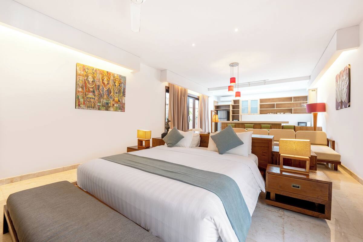A modern hotel room with a large bed, bedside tables, a desk, and a chair.