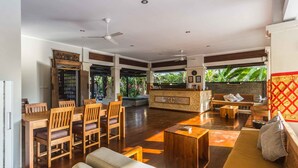 A spacious living area with a wooden dining set, a sofa, and a coffee table.