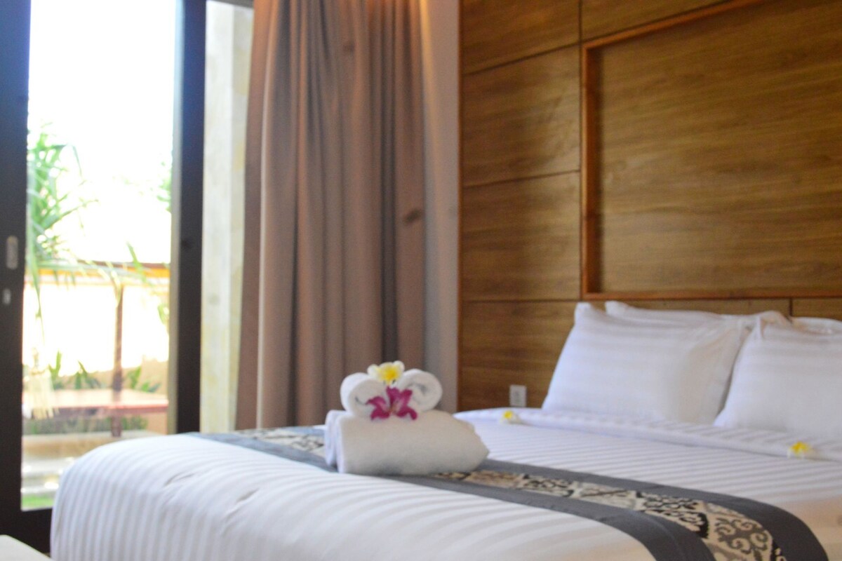 Una habitación de hotel con una cama, un ventanal y una cortina.