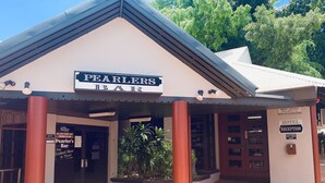 A hotel entrance with a sign reading "Pearlers Bar" and a reception area. - Roey Backpackers & Party Bar (Broome)
