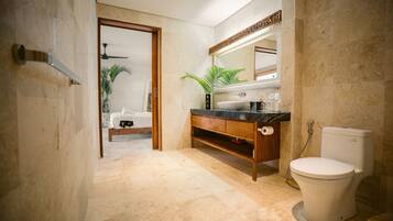 A modern bathroom with a marble floor, a wooden vanity, a white toilet, and a large mirror.