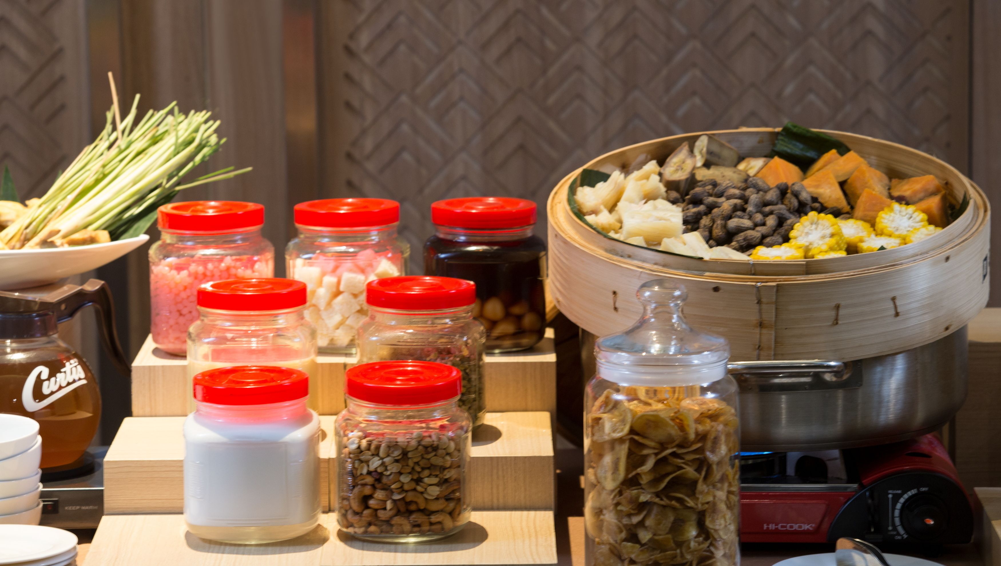 A buffet setup with various food items and condiments.