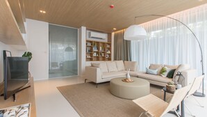 A modern living room with a sofa, coffee table, and a television. - Veranda Residence Pattaya Pool Villa (Pattaya)