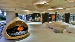 A modern interior with a hanging chair, white ottomans, and a unique ceiling design. - Veranda Residence Pattaya Pool Villa (Pattaya)
