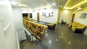 Un'ampia hall con una scala, una reception e zone relax.