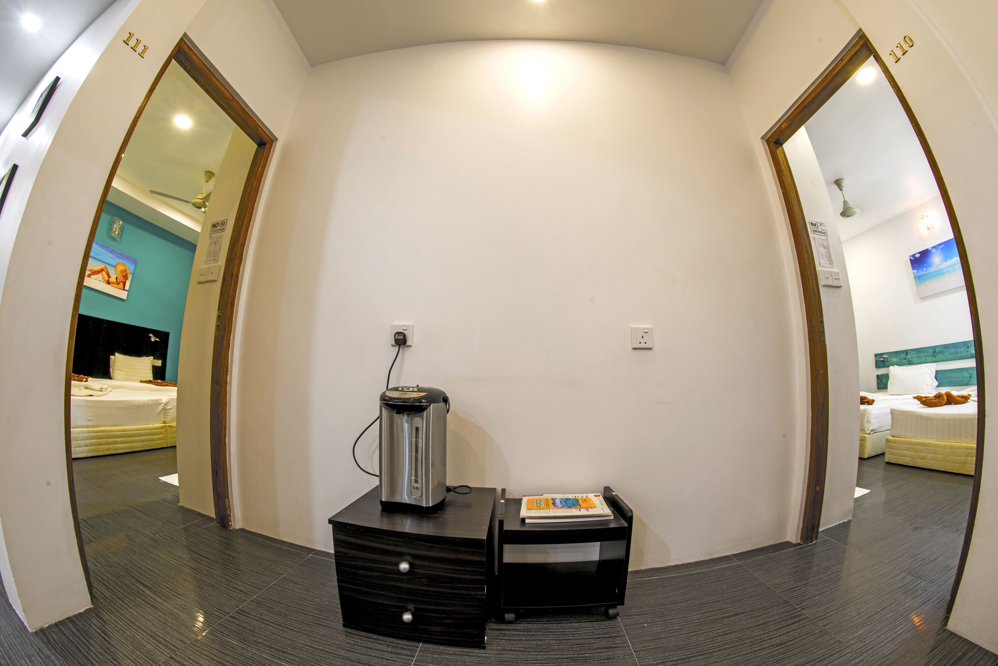 Une chambre d’hôtel équipée d’une kitchenette, d’un lit et donnant sur le couloir.