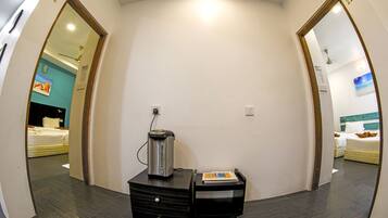Une chambre d’hôtel équipée d’une kitchenette, d’un lit et donnant sur le couloir.