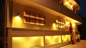A building with multiple windows and a garage door, illuminated by warm lighting.