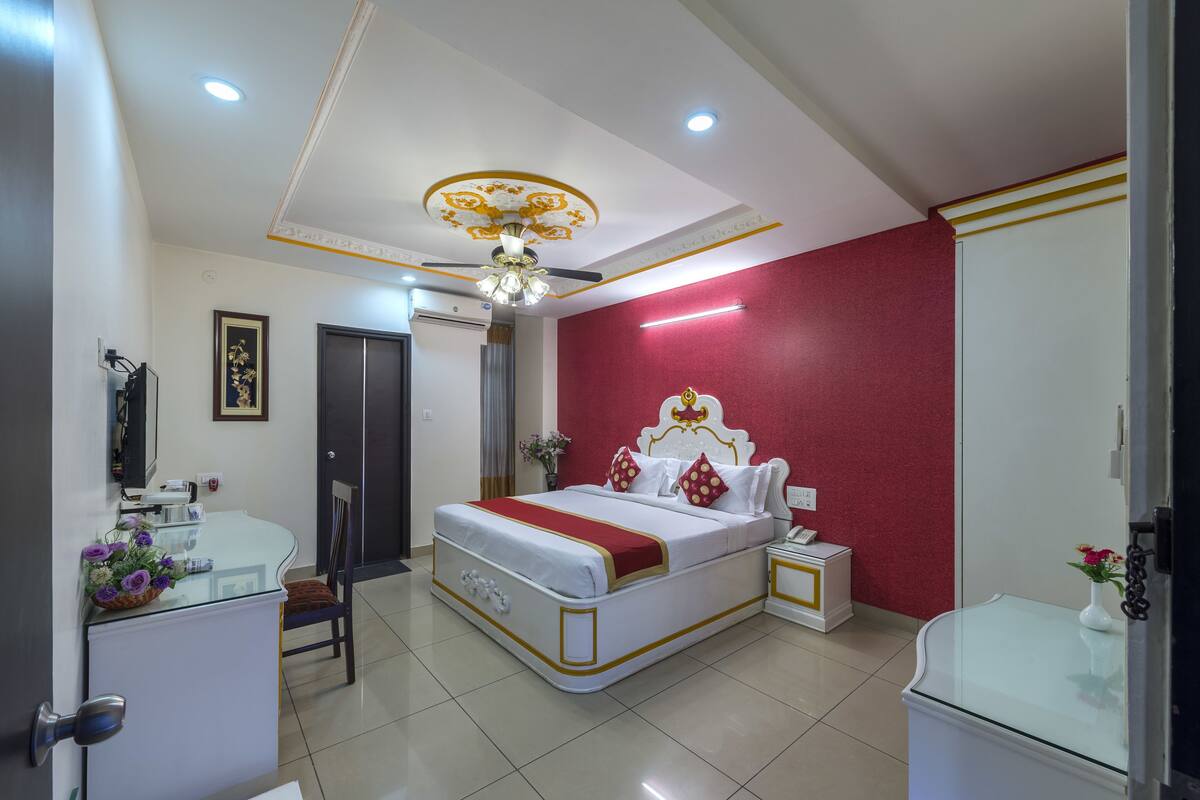 Habitación de hotel con cama, mesita de noche y escritorio con silla.