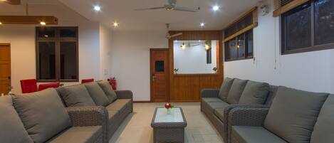 A modern living room with two grey sofas, a small coffee table, and a ceiling fan.