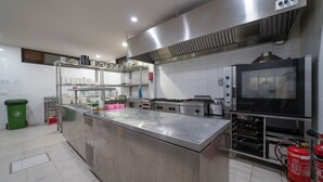 A commercial kitchen with stainless steel appliances, a large island, and a fire extinguisher.