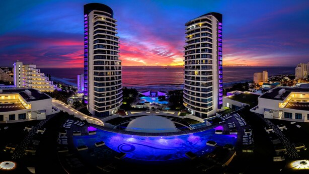 Un hôtel de grande hauteur doté d’une piscine et offrant une vue imprenable sur le coucher de soleil.