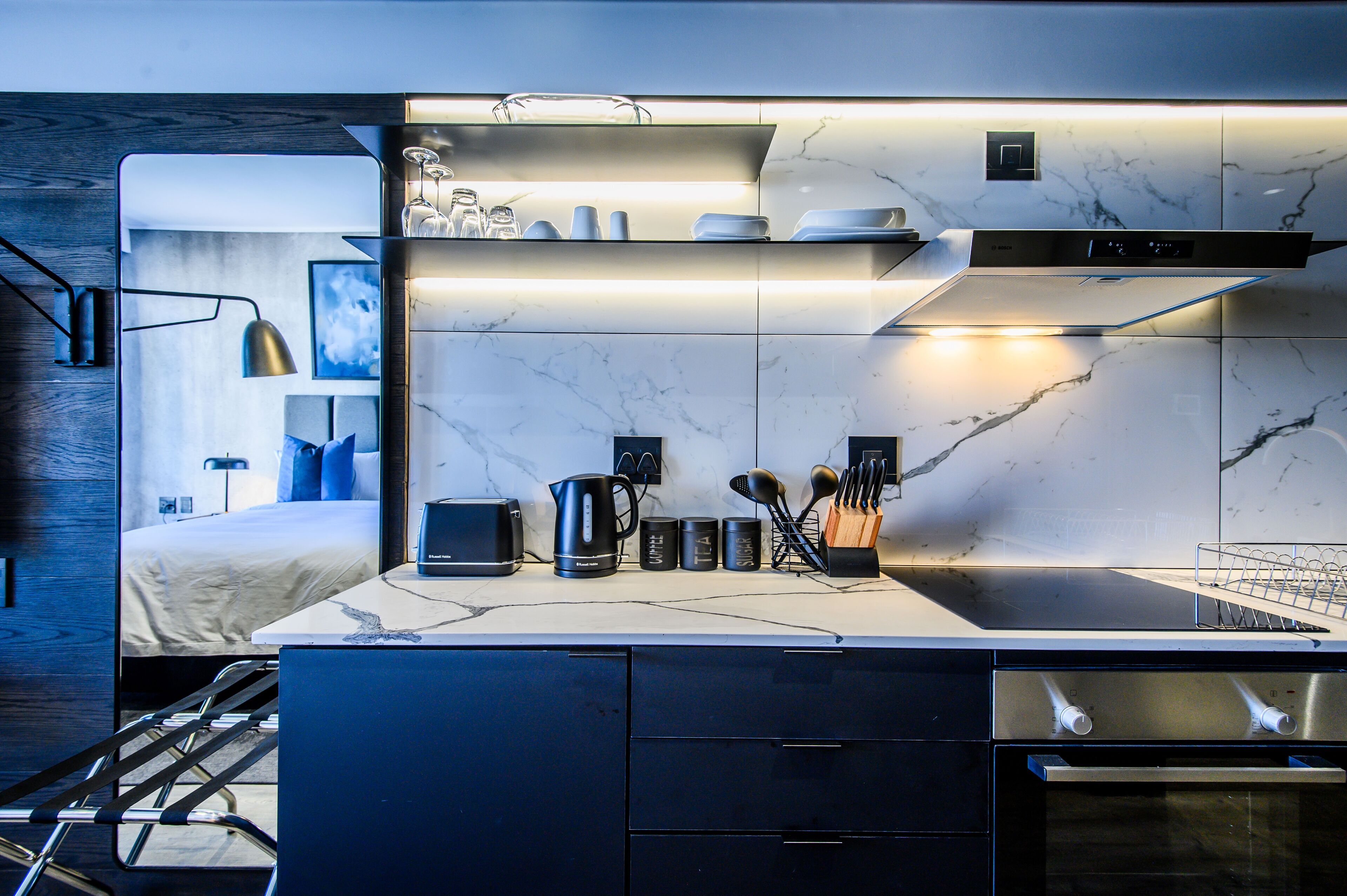 Una cocina moderna con horno integrado, cafetera y hervidor.