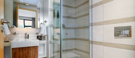Une salle de bain moderne avec une douche à parois de verre, un meuble-lavabo en bois et un grand miroir.