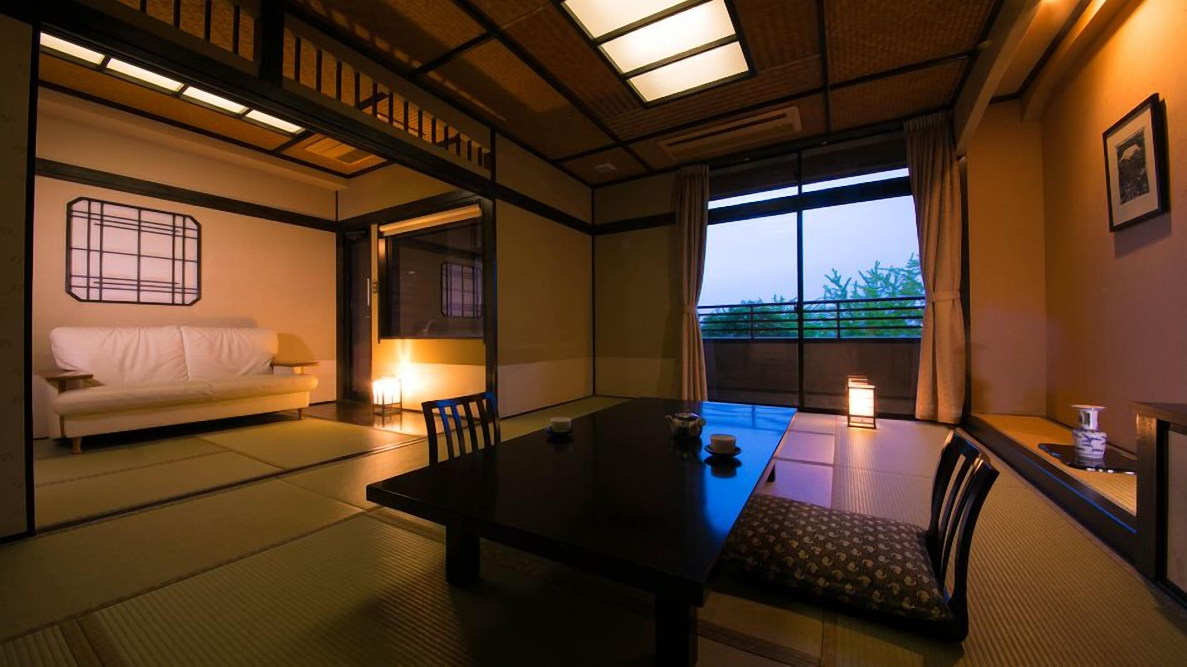 Une pièce de style japonais traditionnel, avec un sol recouvert de tatamis, une table basse, un canapé et une porte coulissante.