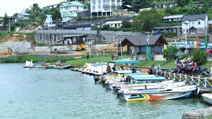 Un port de plaisance avec des bateaux amarrés, un petit quai et un bâtiment doté d’un toit végétalisé.