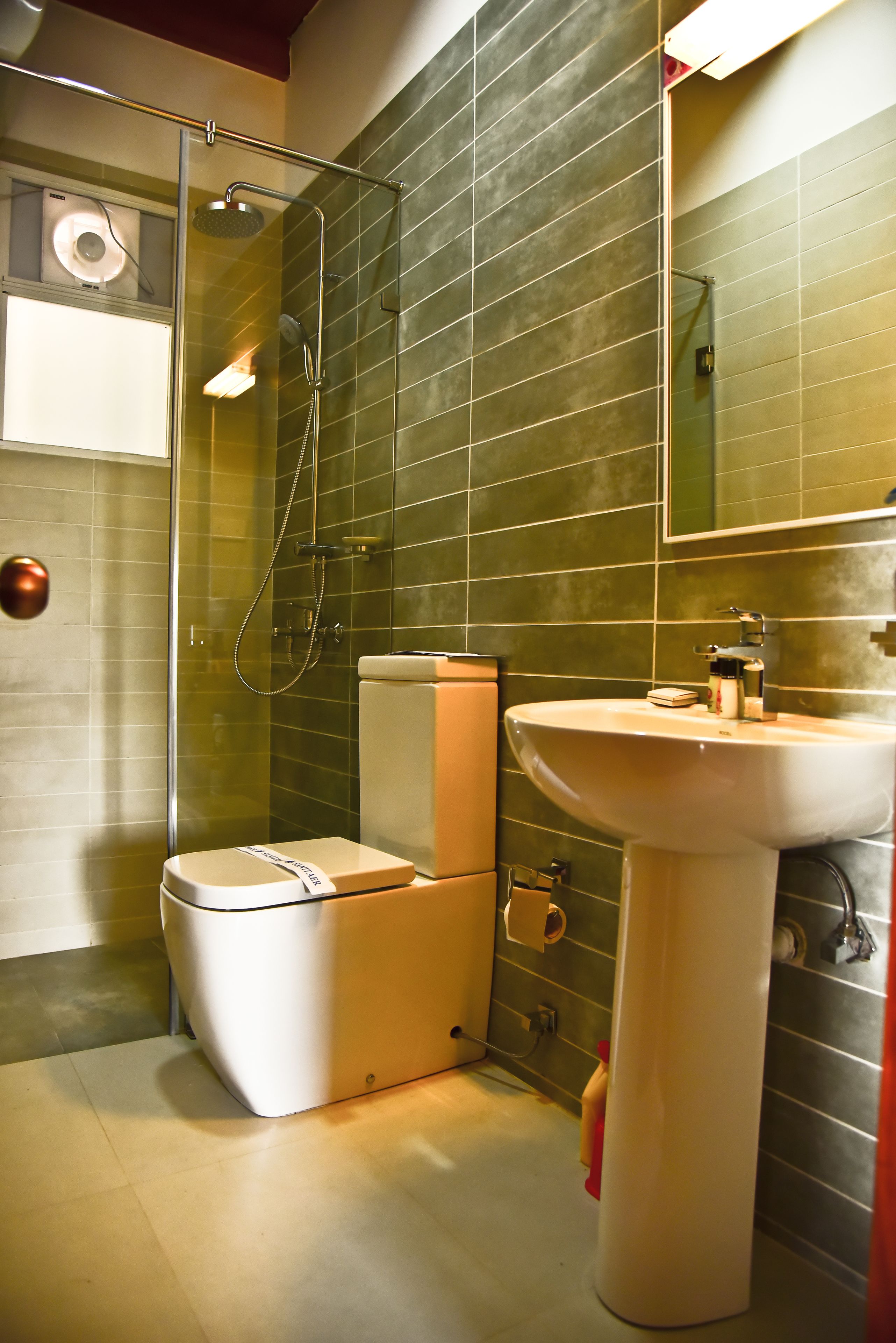 Un baño con ducha acristalada, inodoro y lavamanos.