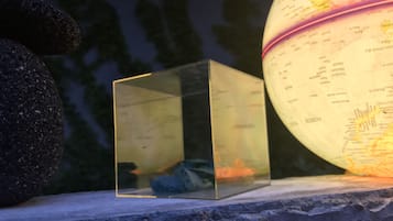 Un cube transparent contenant une carte à l’intérieur, posé sur une corniche en pierre, avec un globe à côté.