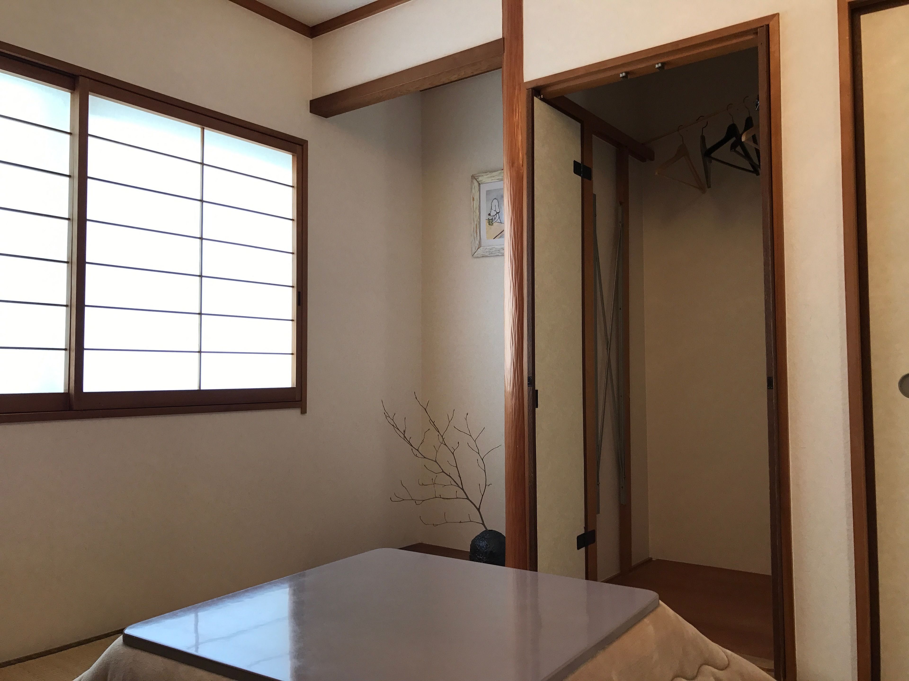 A room with a tatami mat, a sliding door, and a window with horizontal blinds.