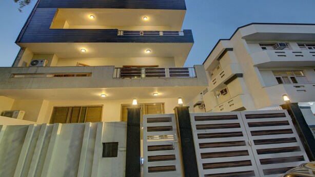 A multi-story residential building with balconies, a gated entrance, and multiple air conditioning units. - Itsy Hotels Swastika Inn Sector 26 (Noida)