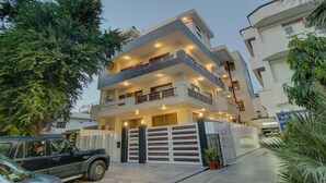 A multi-story residential building with balconies, a gated entrance, and surrounding greenery. - Itsy Hotels Swastika Inn Sector 26 (Noida)