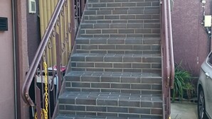 A staircase with metal railings and a handrail, leading to a building entrance. - Guesthouse Kyozen (Kyoto)