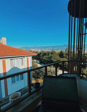 A balcony with a view of a cityscape, including buildings and a distant mountain range. - Bolu Otel (Bolu)