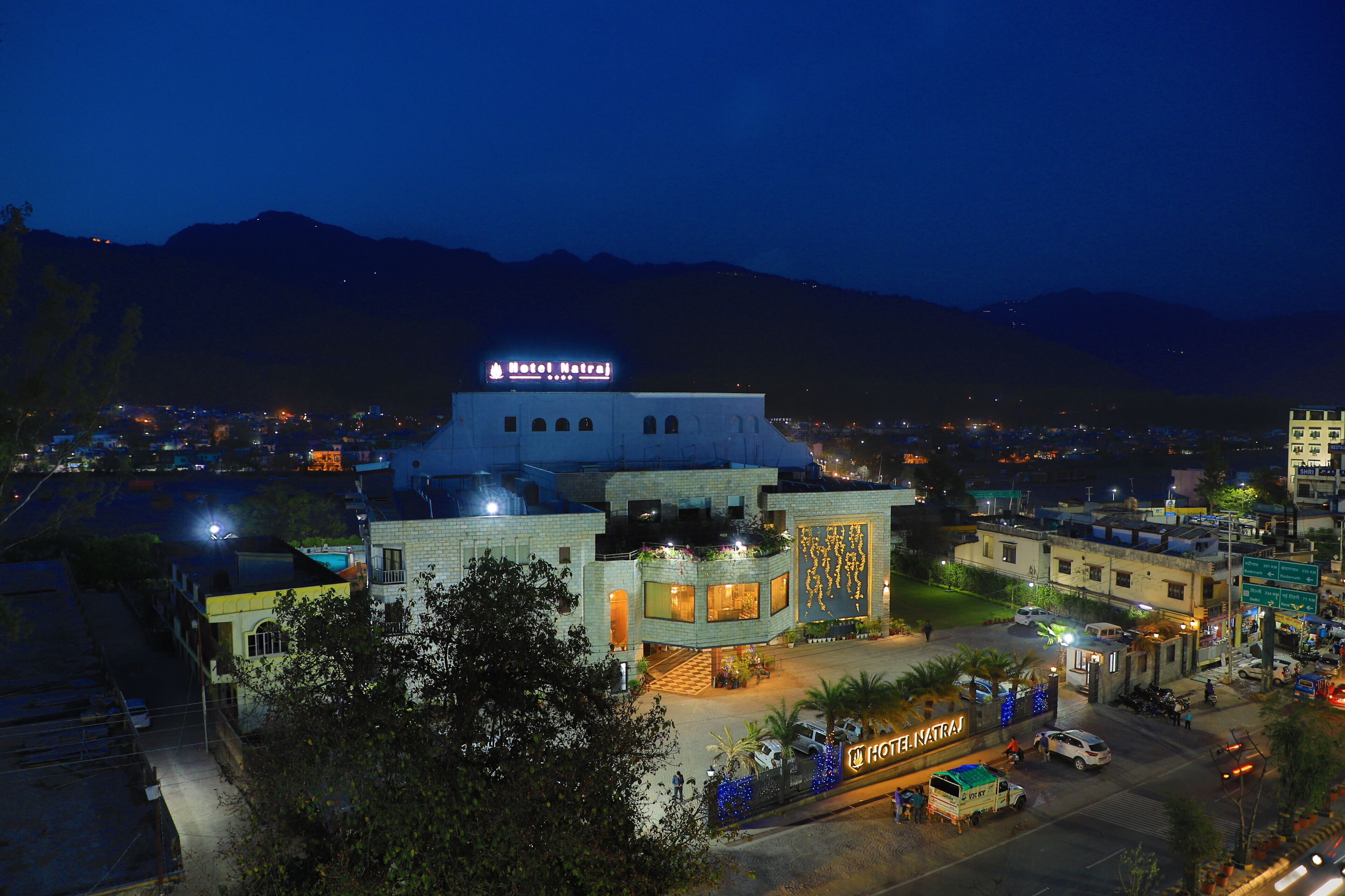 Un hotel con un cartello ben visibile, un cortile interno e vista sulla zona circostante.