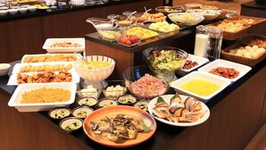 Un buffet proposant une variété de plats, notamment des fruits de mer, des salades et du pain.