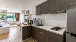 A modern kitchen with dark wood cabinets, white countertops, and stainless steel appliances.