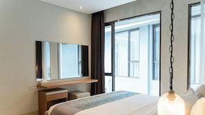 A modern hotel room with a large bed, a desk, a mirror, and a view of the outside. - Mentari Hill View 8 BR heated pool and movie room (Bandung)