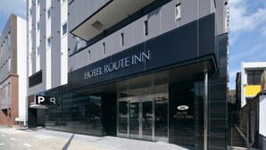 A modern building with a prominent sign for Hotel Route Inn. - Hotel Route Inn Toyohashi Ekimae (Toyohashi)