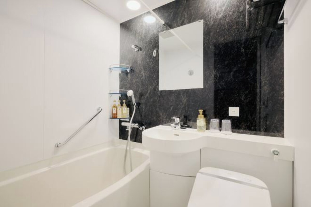 A modern bathroom with a bathtub, a sink, and a toilet.