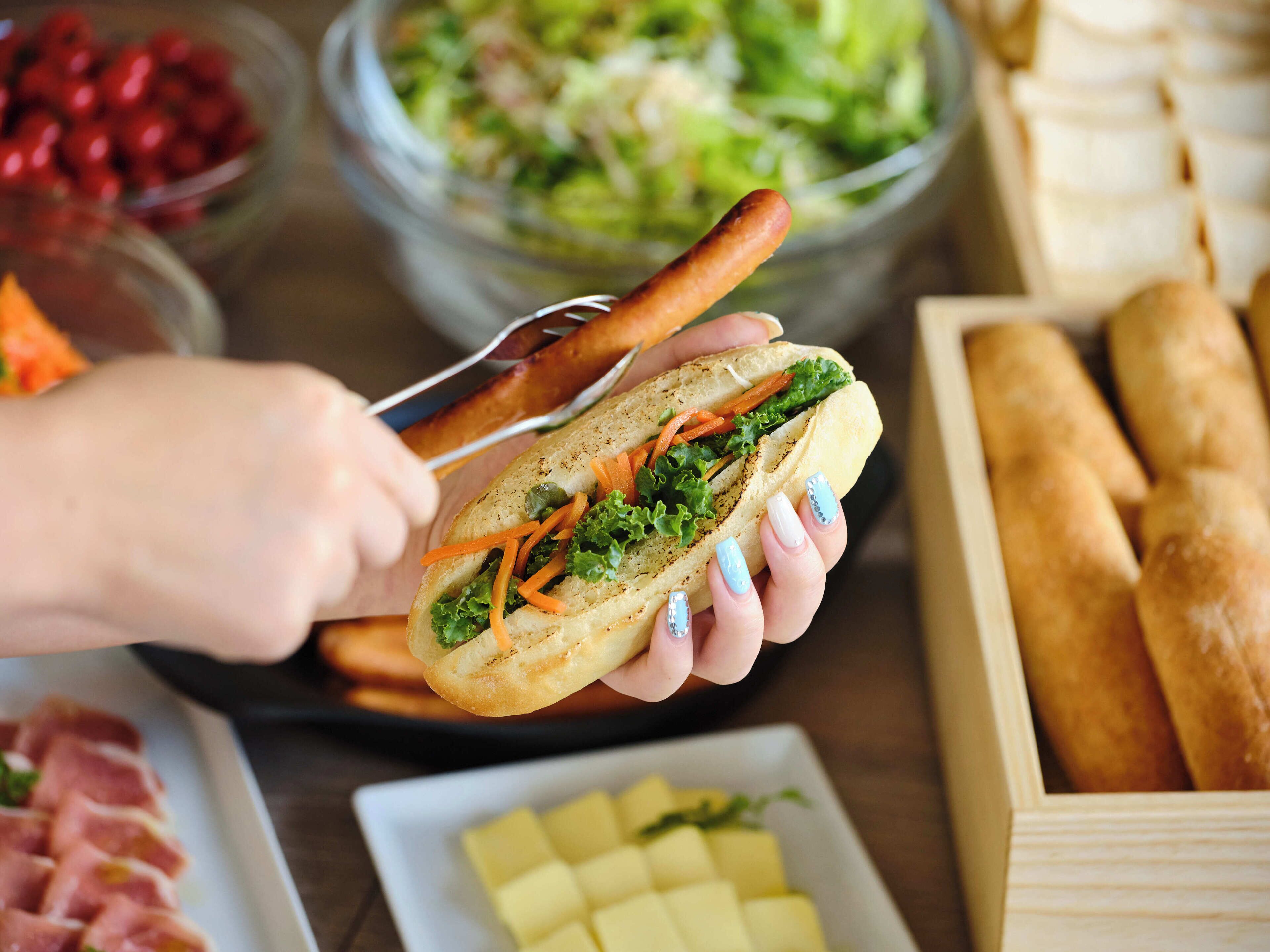 A person holding a sandwich with a fork.