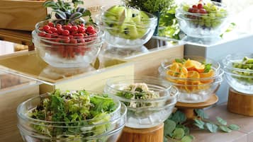 A buffet with various food options including salads, fruits, and other dishes.