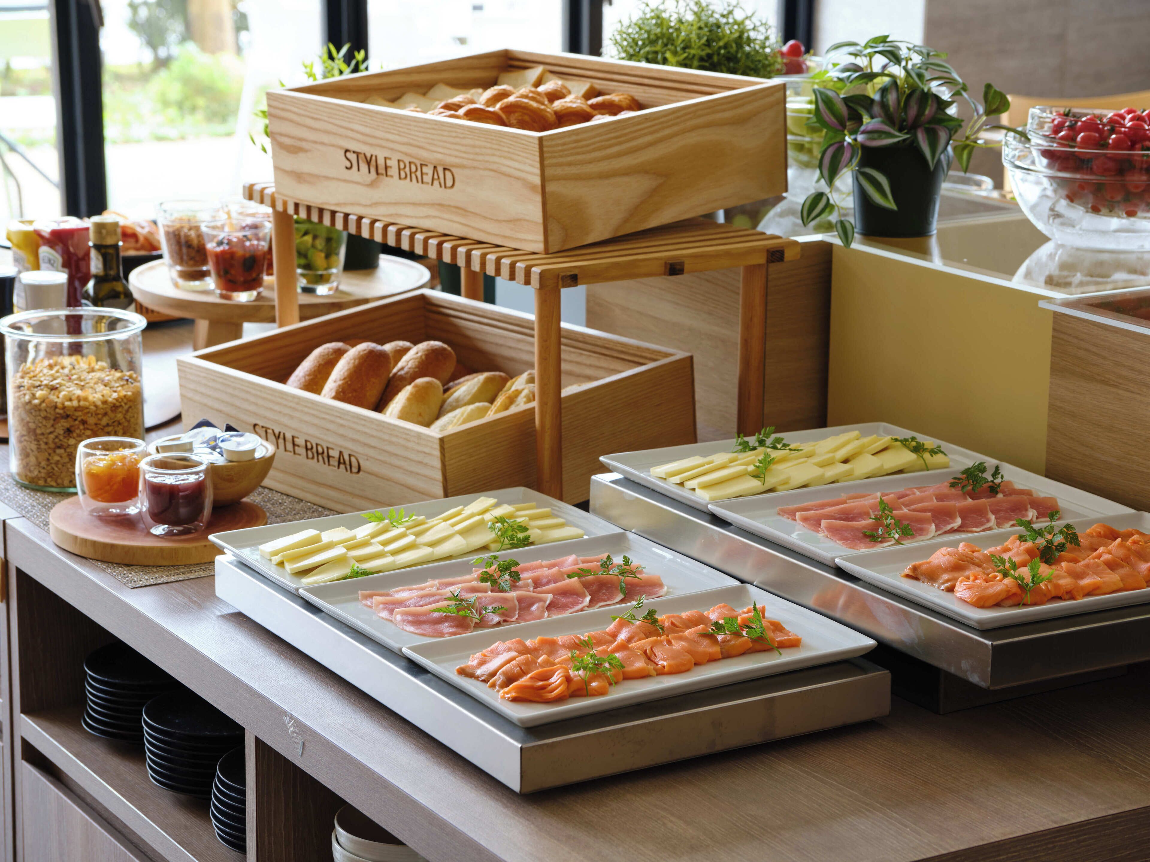 Una mesa de buffet con diversos alimentos, como pan, queso y embutidos.