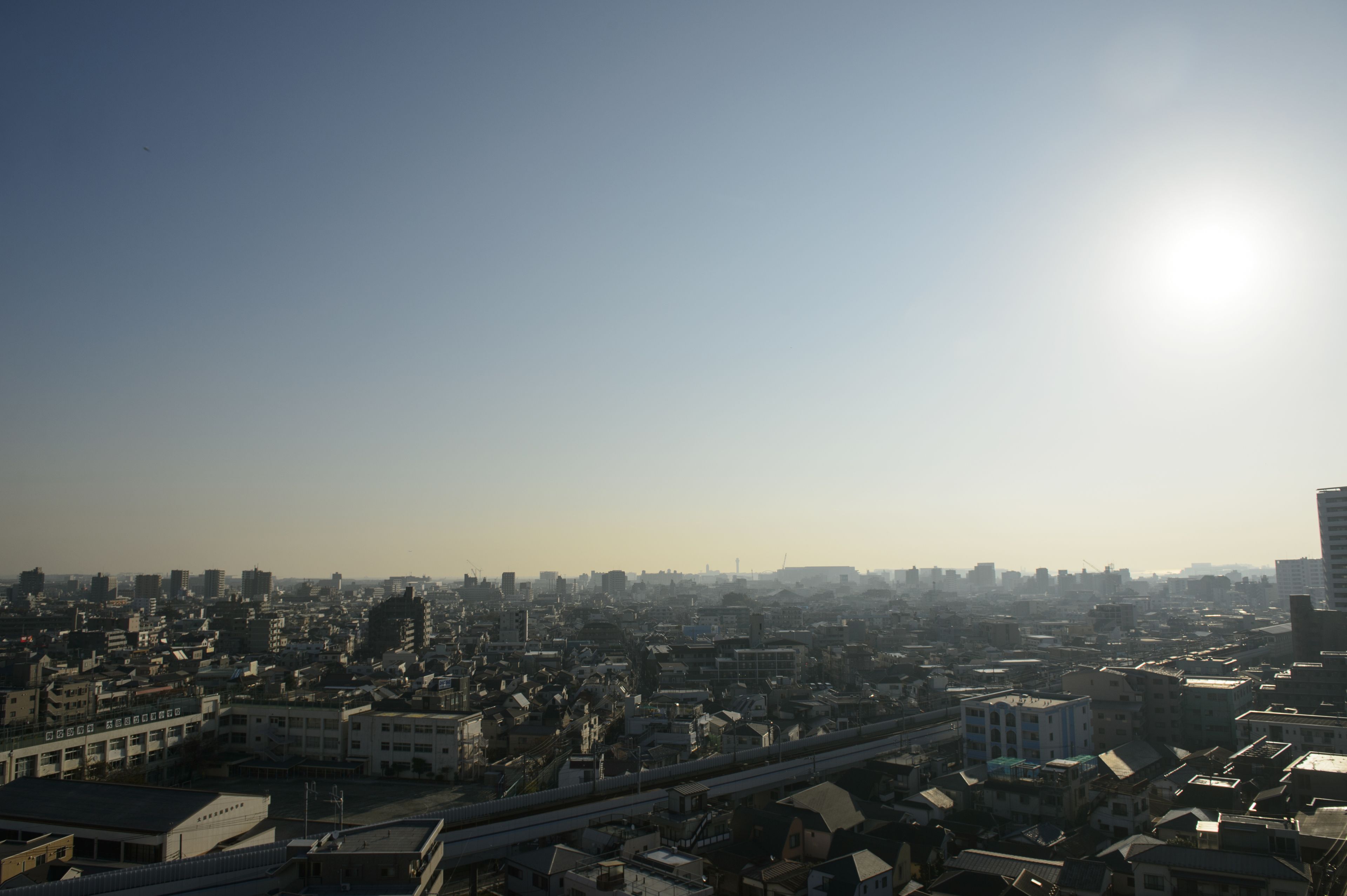 Eine Stadtansicht mit blauem Himmel und strahlender Sonne.