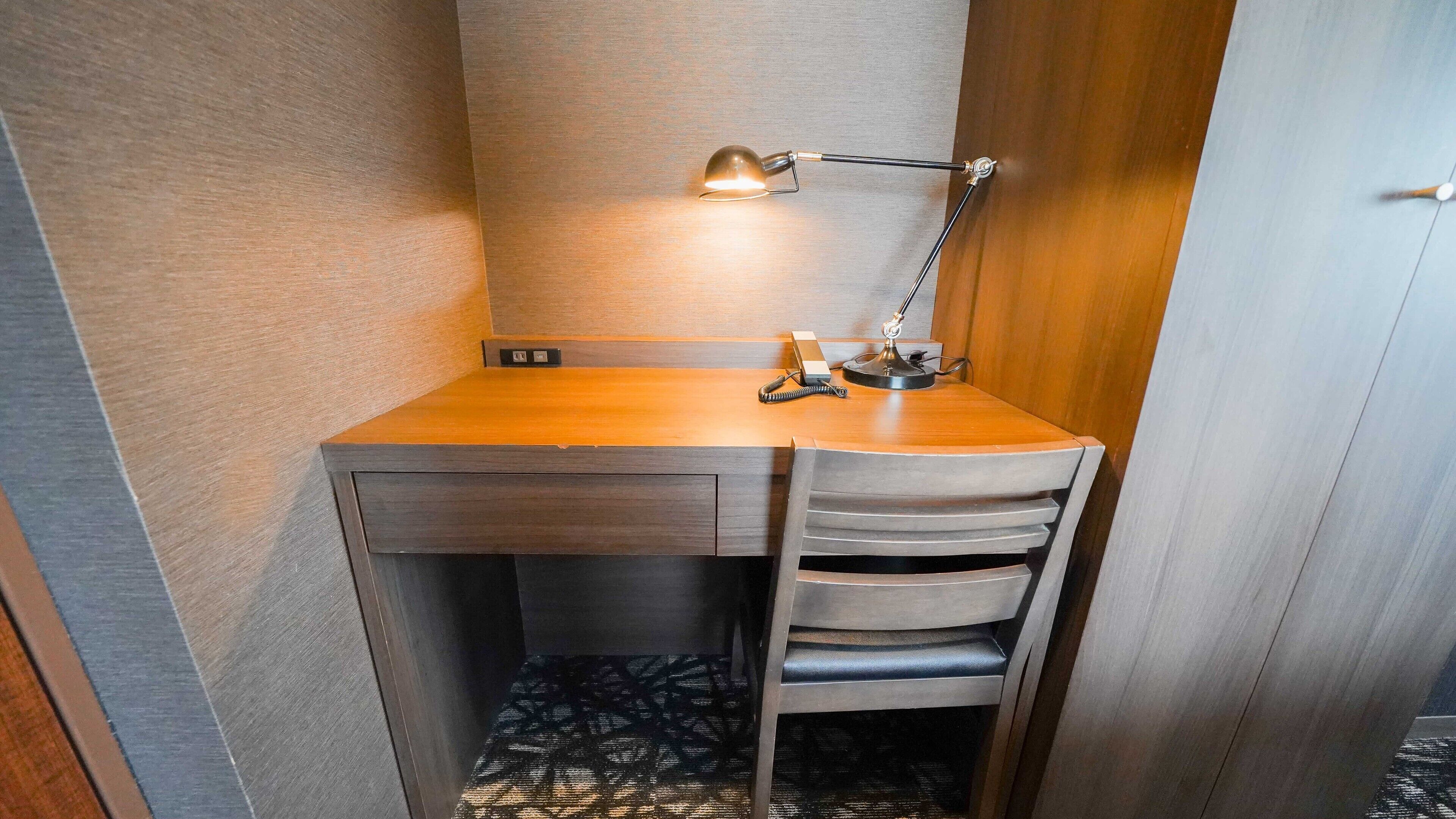 Un espacio de trabajo funcional con escritorio, silla y lámpara.