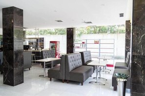 A modern hotel lobby with marble columns, seating areas, and a bar. - D'Grande Hotel (Batam)