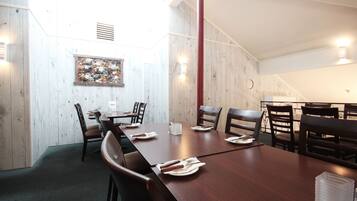 A conference room with a long table, chairs, and a painting on the wall.