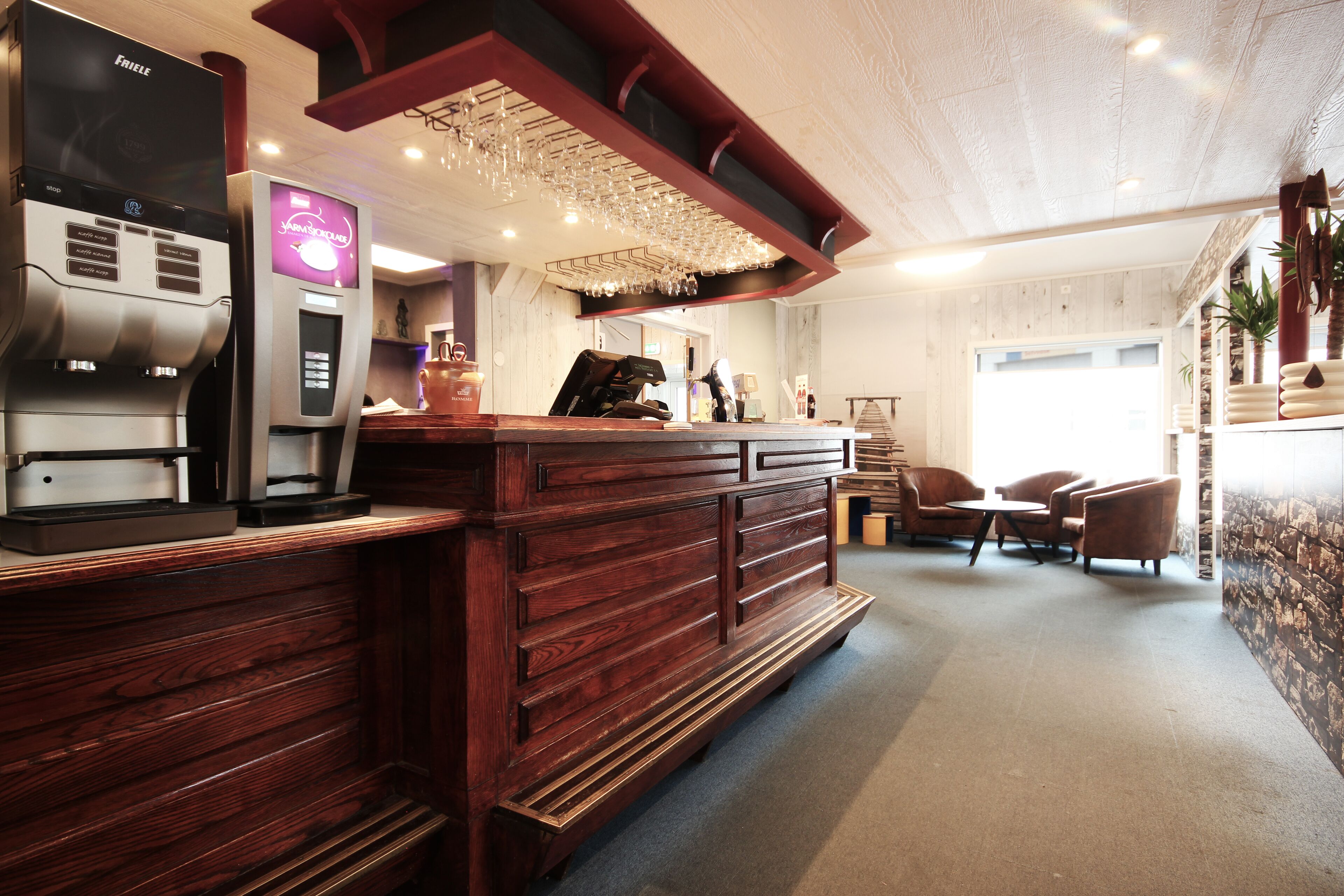 A bar area with a coffee machine, seating, and a counter.