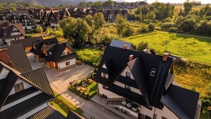 A traditional European village with chalet-style houses, a central square, and a church. - Willa Wrzos (Zakopane)