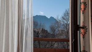 A view through a window with a curtain, featuring a mountain range in the background. - Willa Wrzos (Zakopane)
