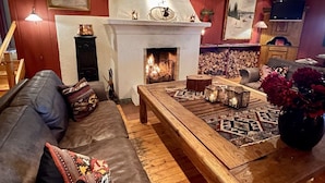 Una sala de estar acogedora con chimenea, un sofá y una mesa de centro.