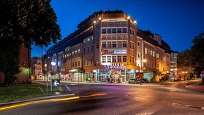 A hotel with a prominent sign, multiple floors, and a corner location. - Sky Business Hotel (Legnica)