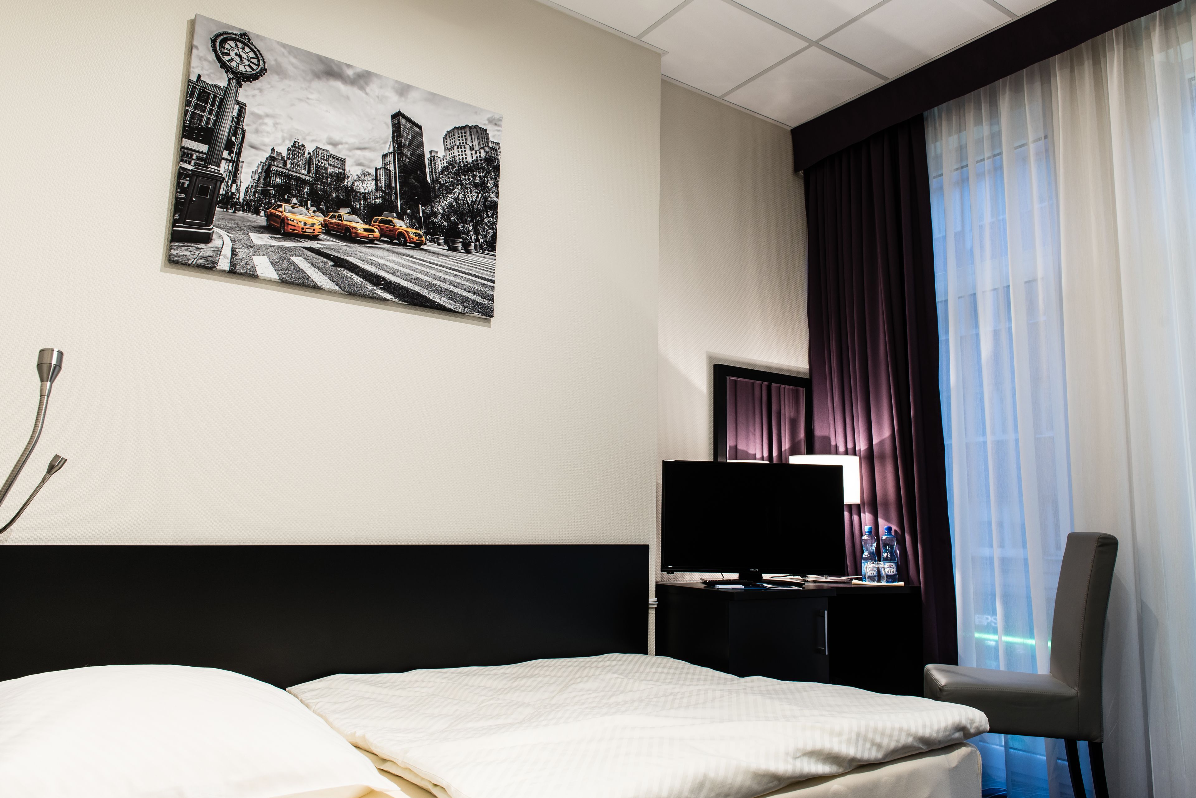 أغطية فراش متميزة وخزنة داخل الغرفة ومكتب وتجهيزات عازلة للصوت