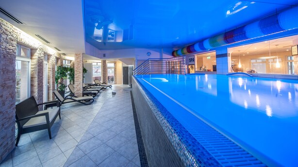 A swimming pool area with lounge chairs and a spa sign. - Sky Business Hotel (Legnica)